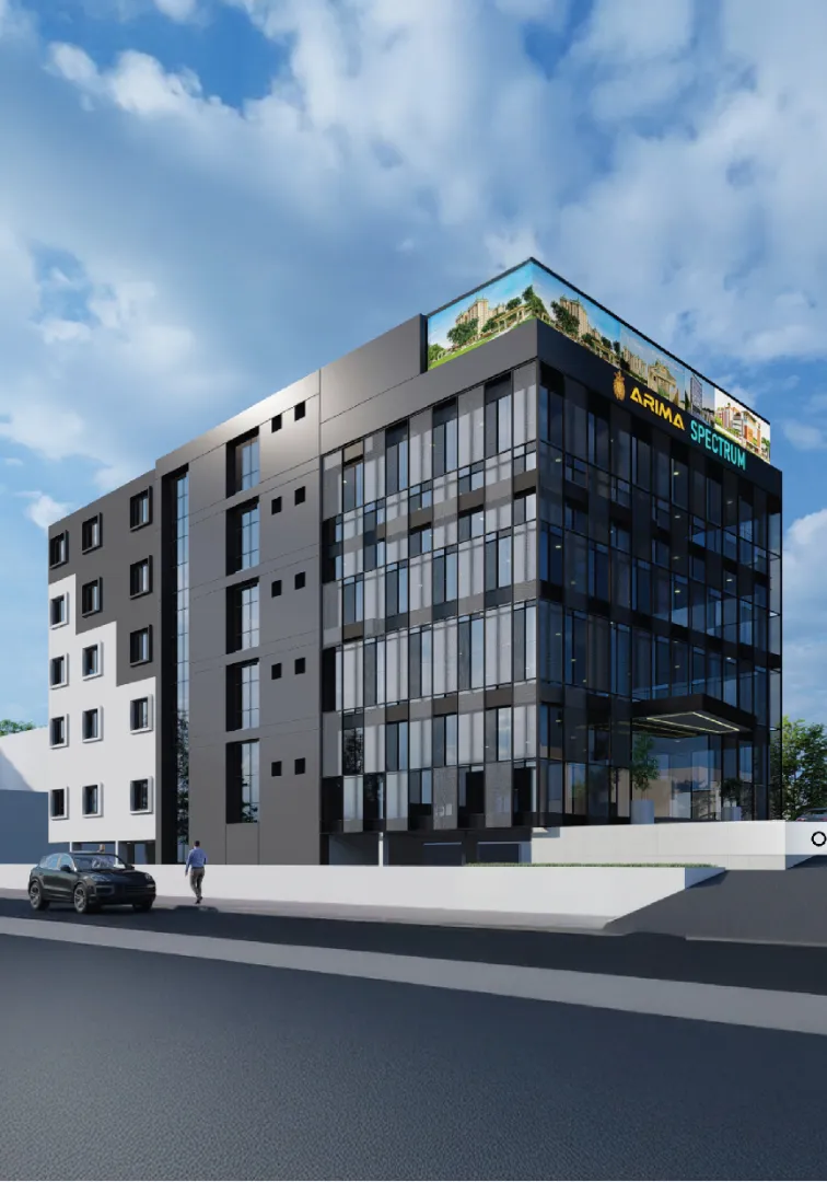 Daytime view of a sleek black-and-glass commercial building with large windows, rooftop signage, and a car parked along the street in front.