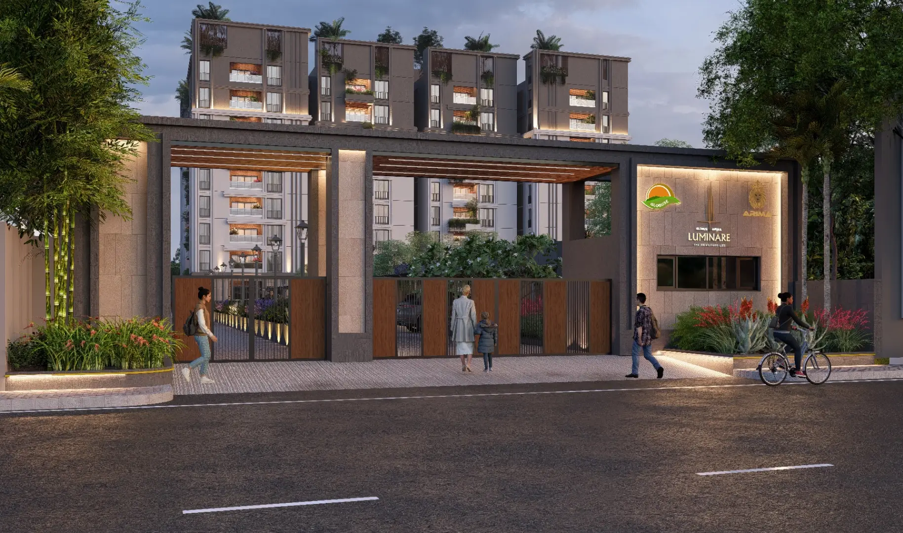 Evening view of a modern gated apartment entrance with warm lighting, landscaped greenery, and people walking along the street in front of the residential complex.